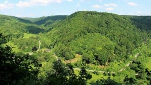 Green valley with wooded hills and country road