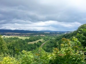 Landscape with valley, forests and village under a cloudy sky