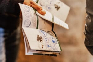 Hand hält Heft mit gesammelten Stempeln