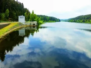Reservoir with forest and small building on the shore