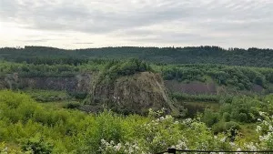 Green rocky landscape with forest and cloudy sky