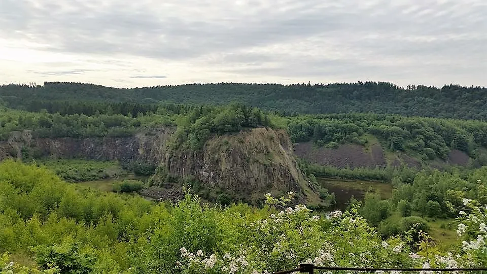 Green rocky landscape with forest and cloudy sky