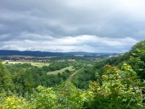 Landscape with valley, forests and village under a cloudy sky