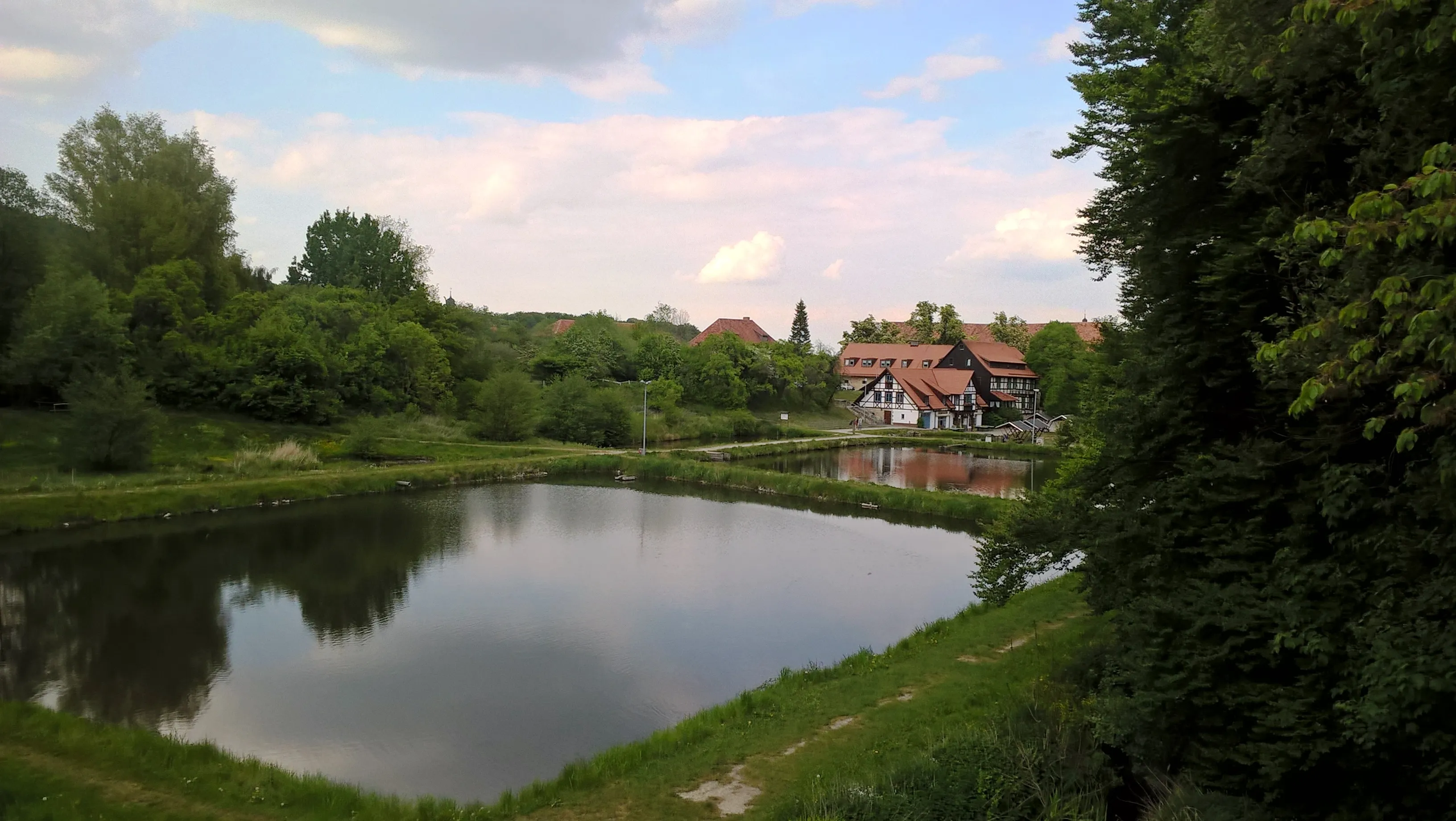 Half-timbered house by the lake with green landscape