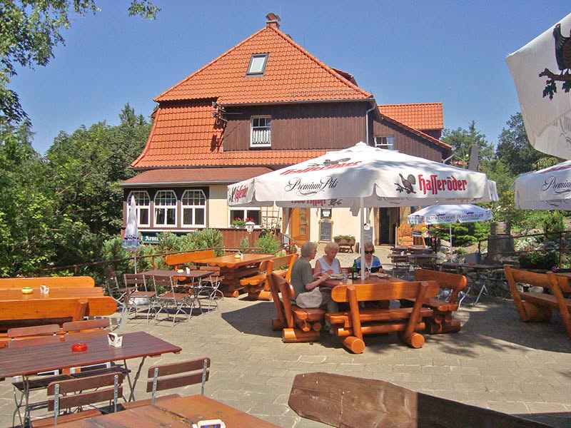 Gemütlicher Biergarten mit Holztischen und Sonnenschirmen
