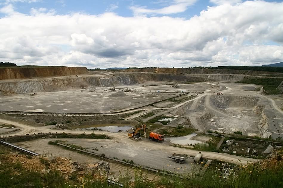 Stort stenbrud med gravemaskiner og lastbiler