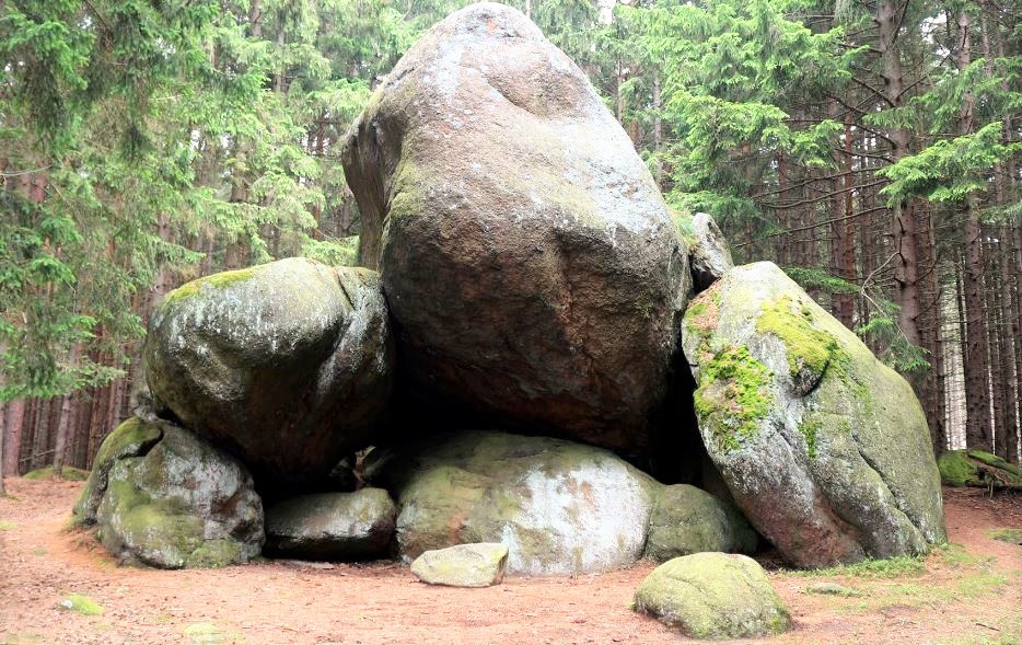 Grote rotsformatie in het bos begroeid met mos