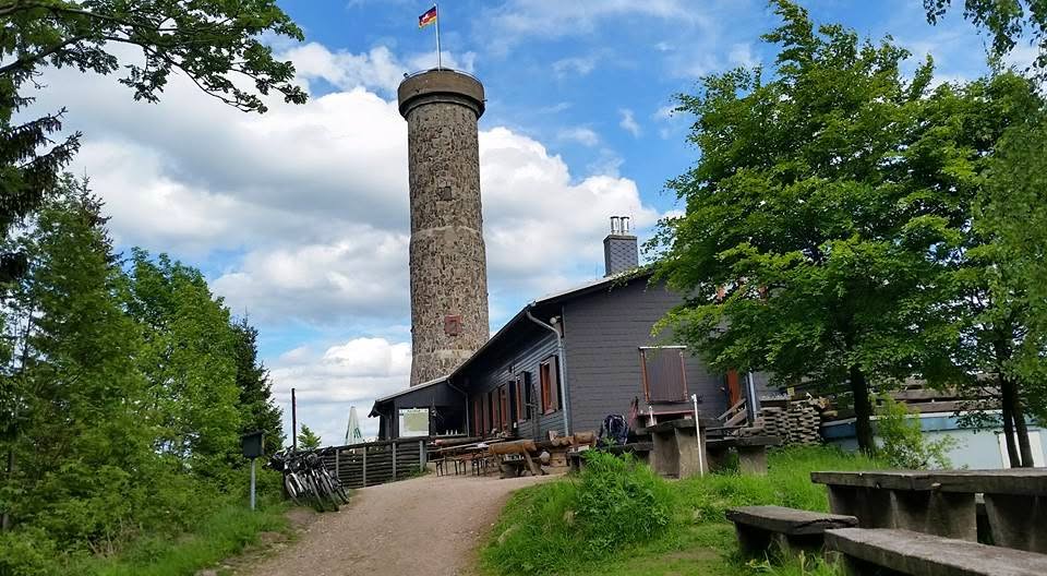 Tour d'observation en pierre à côté d'une cabane de randonnée dans la verdure