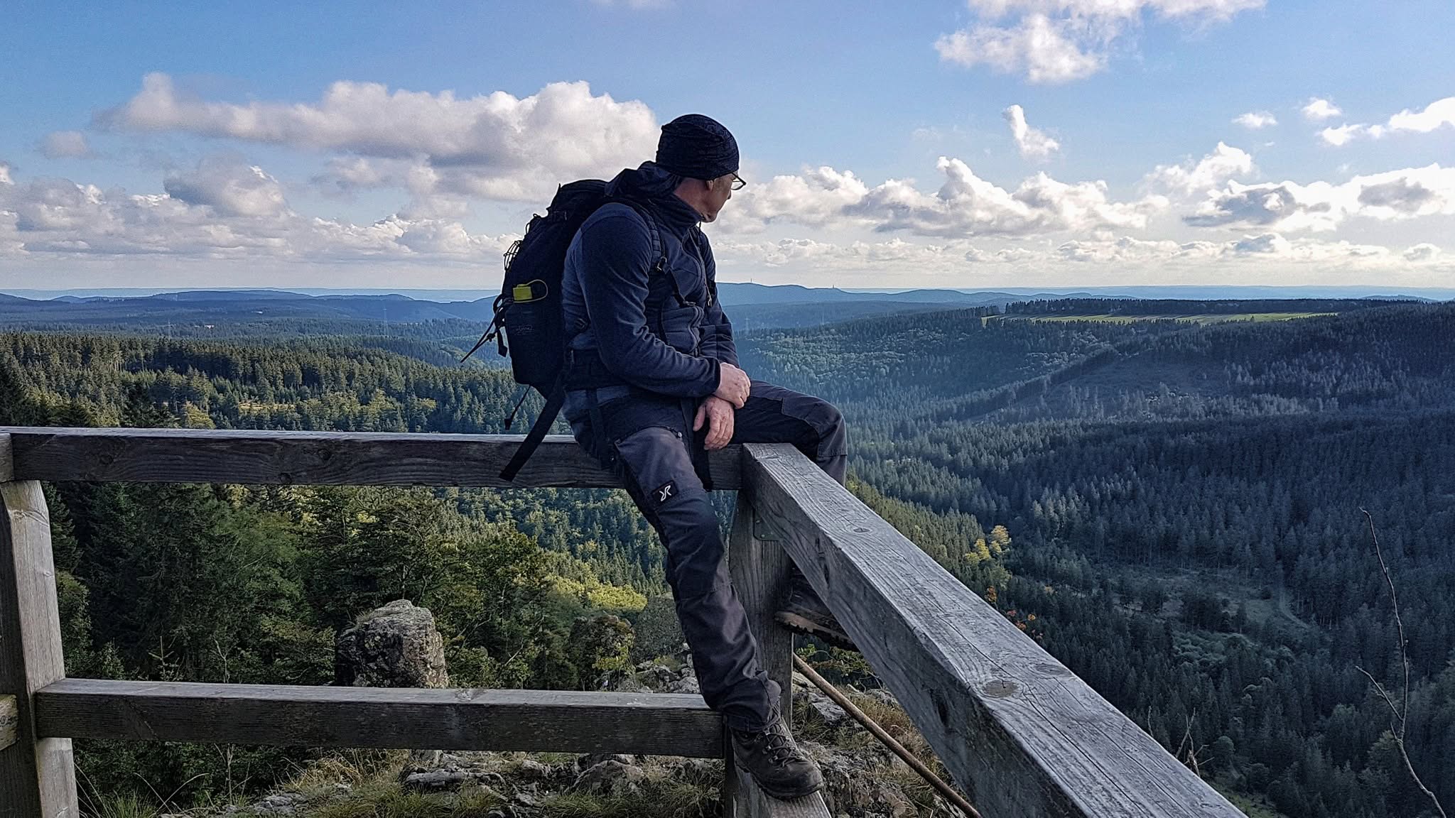 Wandelaar geniet van het uitzicht over beboste bergen