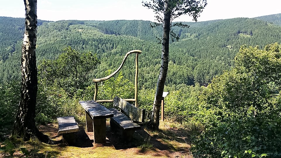 Aussichtsplatz mit Holzbänken im grünen Waldgebirge