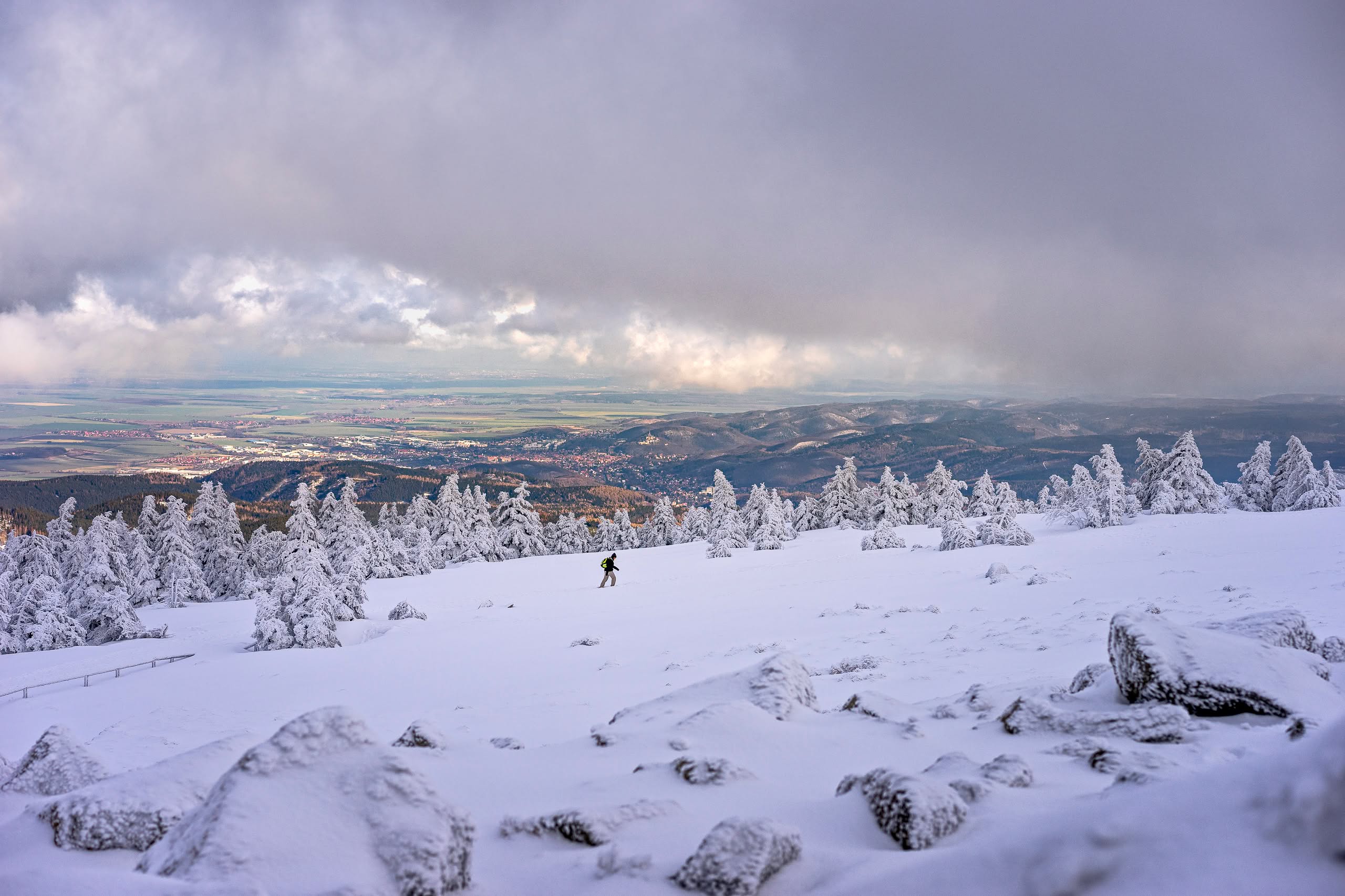 Besneeuwde Brocken met wandelaar. Winterlandschap met uitzicht op het dal.